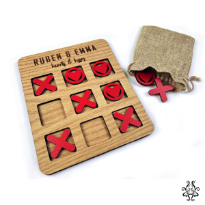 Heart and kiss-shaped game pieces for the personalised Hearts & Kisses Tic-Tac-Toe, displayed alongside a drawstring storage pouch.