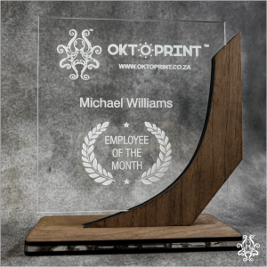 An acrylic and wooden trophy with an engraved design featuring "OKTOPRINT" branding, the name "Michael Williams", and the title "Employee of the Month".