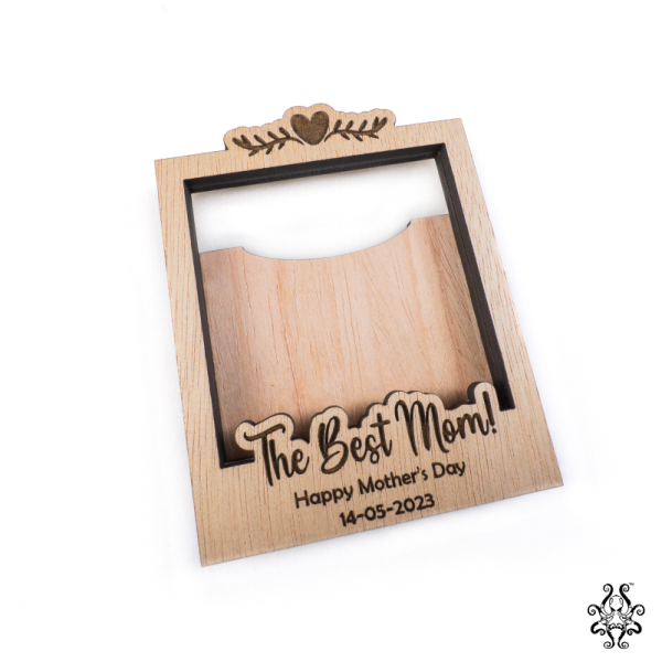 A blank wooden polaroid frame, with personalised engraving and no photo, showing the space for inserting pictures.