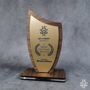 Shield-shaped trophy with walnut veneer and gold ABS, featuring customizable text for awards.